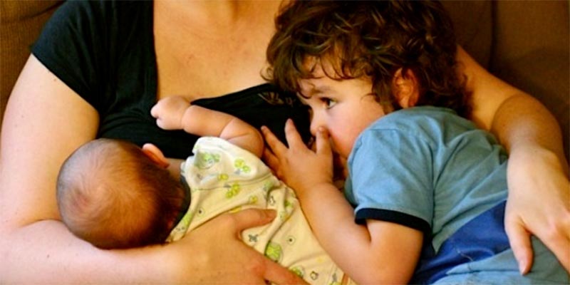 Mother breastfeeding 2 babies. Having more than 1 baby can add to engorgement.