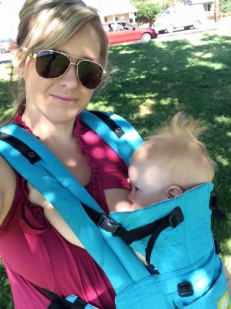 Woman carrying baby in a carrier.  Bonding and attachment with or without breastfeeding