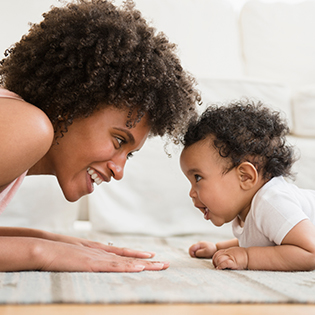 Mother and baby doing tummy time practicing bonding and attachment with or without breastfeeding