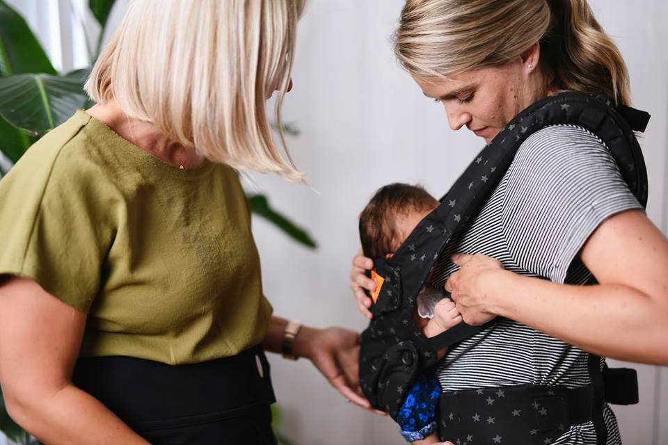 mother breastfeeding in a baby carrier