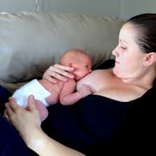 Mother breastfeeding in laid back position